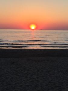 zachód słońca na plaży z zachodem słońca nad oceanem w obiekcie Il Mare w mieście San Vincenzo