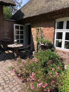a brick house with a patio with a table and flowers at Agerfeld gl. skole in Holstebro