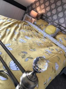 a bed with a yellow comforter on it with at The Little Angel in Whitby