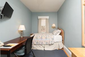 1 dormitorio con 1 cama y escritorio con ordenador en Irving House at Harvard, en Cambridge