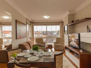 een woonkamer met een tafel en een televisie bij Villa Di Pietro - 404 in Gramado