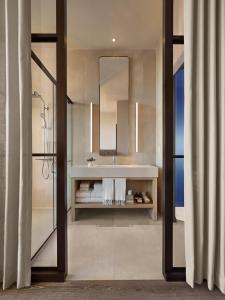 ein Bad mit einem Waschbecken und einem Spiegel in der Unterkunft Asbury Ocean Club Hotel in Asbury Park