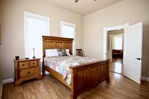 a bedroom with a bed and a dresser and two windows at Roses Haus in New Braunfels