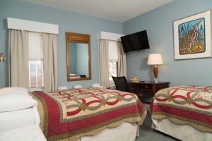 a hotel room with two beds and a mirror at Irving House at Harvard in Cambridge