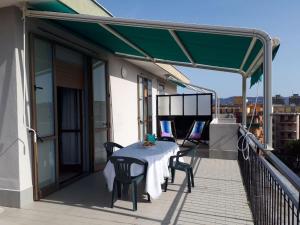 un patio con tavolo e sedie sul balcone. di Attico trilocale con solarium a Borghetto Santo Spirito a Borghetto Santo Spirito