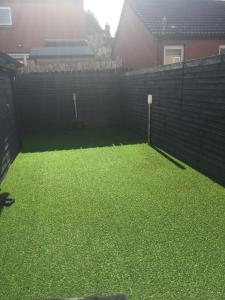 a backyard with a fence and green grass at 2 bedroom house Belfast city in Belfast