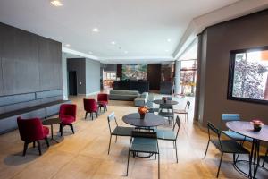 un restaurante con mesas y sillas y un sofá en Carlton Plaza Hotel Uberlandia, en Uberlândia