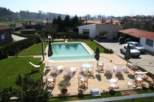 a swimming pool with a group of chairs and a table at Casa Paz do Outeiro in Paredes de Coura
