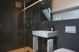 a bathroom with a sink and a shower at Hotel Dom in St. Gallen