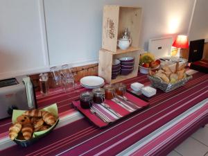 een buffet met brood en andere voedingsmiddelen op tafel bij L'Horizon des Landes in Doazit