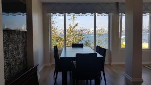 a dining room table with chairs and a view of the water at Istanbul Modern Flats with Amazing Sea View in Istanbul