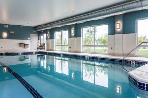 a large swimming pool with blue water in a building at Holiday Inn Express & Suites Allen Park, an IHG Hotel in Allen Park