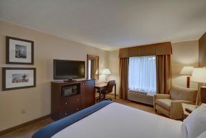 a hotel room with a bed and a flat screen tv at Holiday Inn Express Keene, an IHG Hotel in Keene