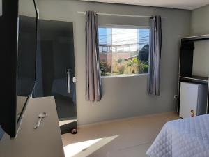 1 dormitorio con cama y ventana en Pousada Viva Maragogi, en Maragogi
