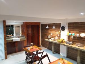 a kitchen with a table and chairs and a counter at Pousada das Pedras in Itacuruçá