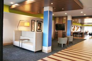 eine Lobby mit einem Sofa, einem Tisch und einem TV in der Unterkunft Holiday Inn Express & Suites Clarion, an IHG Hotel in Clarion