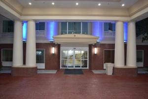 a building with columns in front of a building with blue lights at Holiday Inn Express Hotel & Suites Gainesville by IHG in Gainesville
