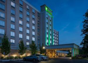 um hotel com carros estacionados num parque de estacionamento em Holiday Inn Hartford Downtown Area, an IHG Hotel em East Hartford