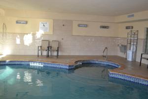 una piscina con due sedie al centro di Holiday Inn Express Hotel & Suites Gainesville, an IHG Hotel a Gainesville