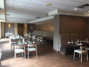 una sala da pranzo con tavoli e sedie in un ristorante di Holiday Inn Budd Lake - Rockaway Area by IHG a Budd Lake