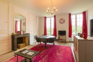 een woonkamer met een tafel en een open haard bij Château Turgot Gîtes in Bons-Tassily