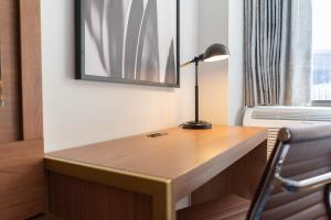 a desk with a lamp and a chair in a room at Hotel Indigo Detroit Downtown, an IHG Hotel in Detroit