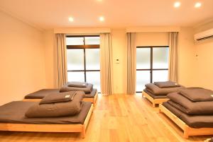 three beds in a room with windows at Enzo Kyoto Gojo E / Vacation STAY 54295 in Kyoto