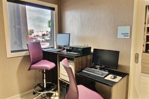 ein Büro mit einem Schreibtisch mit einem Computer und rosa Stühlen in der Unterkunft Holiday Inn Express Fargo - West Acres, an IHG Hotel in Fargo