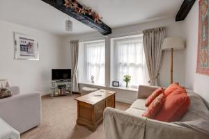 a living room with a couch and a table at Katrinas Apartment By Treetop Property in Cirencester