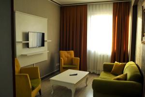 a living room with a couch and chairs and a tv at Lion City Hotel Ankara in Ankara