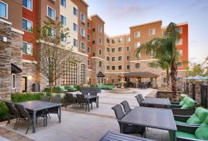a patio with tables and chairs in a courtyard at Staybridge Suites - Gainesville I-75, an IHG Hotel in Gainesville