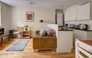 eine Küche und ein Wohnzimmer mit einem Sofa in einem Zimmer in der Unterkunft The Shop By Treetop Property in Cirencester