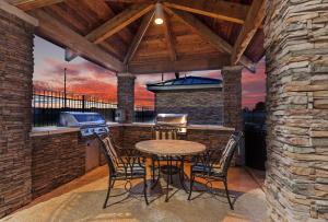 eine Terrasse mit einem Tisch, Stühlen und einem Grill in der Unterkunft Staybridge Suites West Fort Worth, an IHG Hotel in Fort Worth
