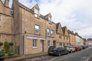 a row of brick houses on a street at Katrinas Apartment By Treetop Property in Cirencester