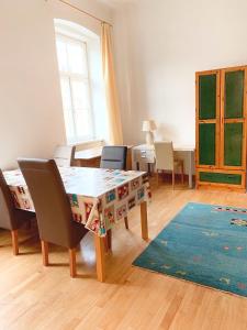 een woonkamer met een tafel en stoelen en een tapijt bij Pension Huber - Apartement Wien 9 in Wenen