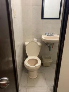 a bathroom with a toilet and a sink at Hotel Posada San Juan in Veracruz