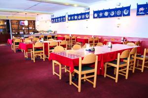 uma sala de jantar com mesas e cadeiras com toalha de mesa vermelha em Express Inn Alvin em Alvin