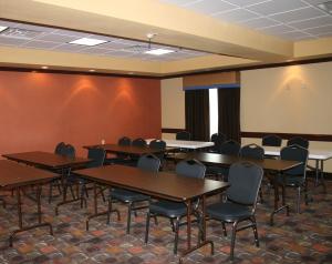 a conference room with tables and chairs and a whiteboard at Holiday Inn Express & Suites George West by IHG in George West