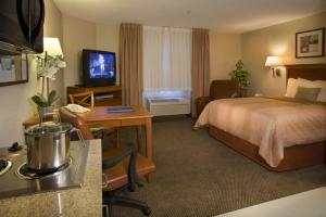 a hotel room with a bed and a television at Candlewood Suites Fredericksburg, an IHG Hotel in Fredericksburg