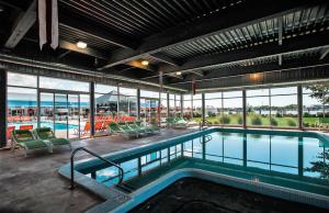 a large swimming pool in a building with windows at Holiday Inn Grand Haven-Spring Lake, an IHG Hotel in Spring Lake