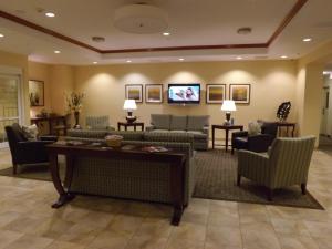 a living room with couches and a flat screen tv at Candlewood Suites Fredericksburg, an IHG Hotel in Fredericksburg