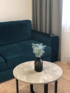 a vase of flowers on a table in a living room at Good Night apartaments in Panevėžys
