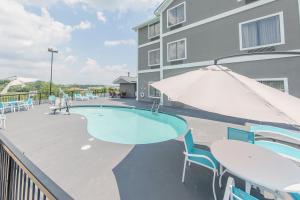 a swimming pool with tables and chairs and an umbrella at Holiday Inn Express Dandridge by IHG in Dandridge