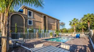 a house with a swimming pool and palm trees at Holiday Inn Express Daytona Beach - Speedway, an IHG Hotel in Daytona Beach