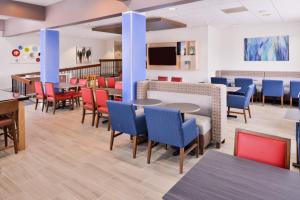 una sala de espera con mesas, sillas y TV en Holiday Inn Express Burlington, an IHG Hotel, en Burlington