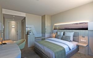a bedroom with a large bed and a kitchen at Holiday Inn Frankfurt Airport, an IHG Hotel in Frankfurt