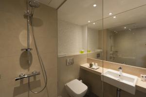 a bathroom with a shower and a toilet and a sink at Holiday Inn Frankfurt Airport, an IHG Hotel in Frankfurt