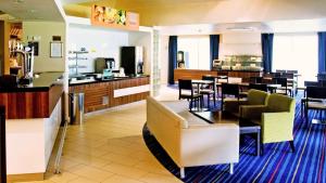 un restaurante con mesas y sillas y un bar en Holiday Inn Express Greenock, an IHG Hotel, en Greenock