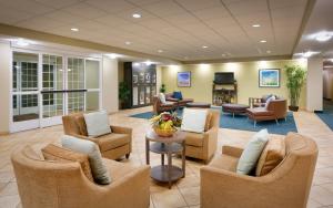 a lobby with couches and chairs and a television at Candlewood Suites Plano East, an IHG Hotel in Plano