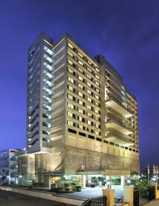 un edificio alto con luces encendidas delante de él en Holiday Inn New Delhi Mayur Vihar Noida, an IHG Hotel, en Nueva Delhi